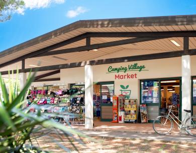 Market del villaggio campeggio con bici e articoli esposti.