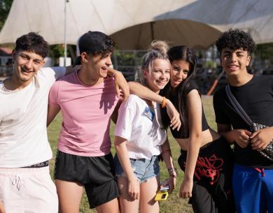 Gruppo di amici sorridenti all'aperto in una giornata di sole.