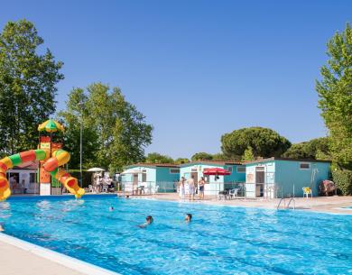 Piscina soleggiata, scivolo colorato, risate e relax estivo all'aperto.