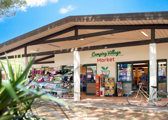 Market del villaggio campeggio con bici e articoli esposti.