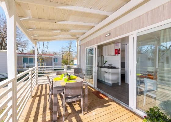 Terrasse mit Tisch und moderner Küche im Mobilheim.