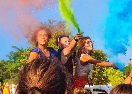 Giovani festeggiano con colori vivaci, sprigionando gioia e libertà all'aperto.