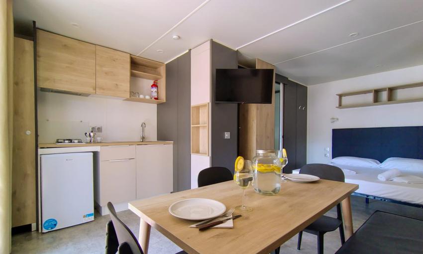 Moderno monolocale accogliente con cucina e camera da letto luminosa.